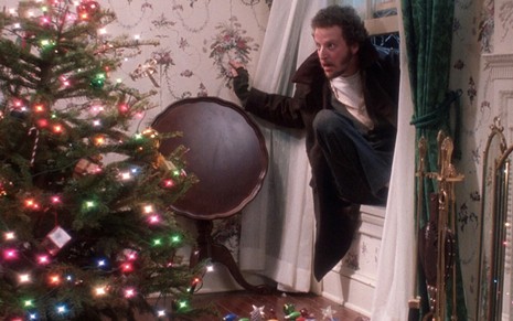O ator Daniel Stern entra por uma janela aberta e dá de cara com uma árvore de natal ricamente adornada em cena de Esqueceram de Mim