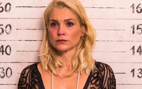 A atrize Flávia Alessandra com expressão de choro em cena em que tem sua foto tirada na cadeia em Êta Mundo Bom!