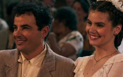 Os atores Anderson Di Rizzi e Camila Queiroz sorriem em cena do casamento de seus personagens Êta Mundo Bom