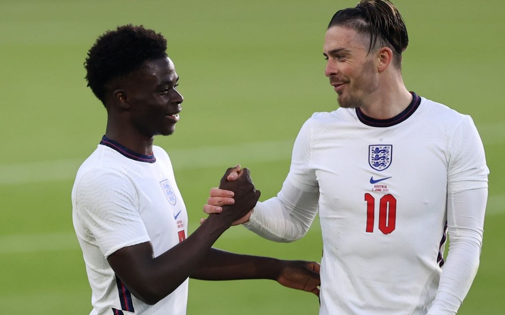 Bukayo Saka e Jack Grealish se cumprimentam com as mãos em jogo da Inglaterra