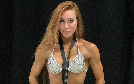 Aline Dahlen exibindo o corpo musculoso, de biquíni com pedrarias e medalha pendurada no pescoço