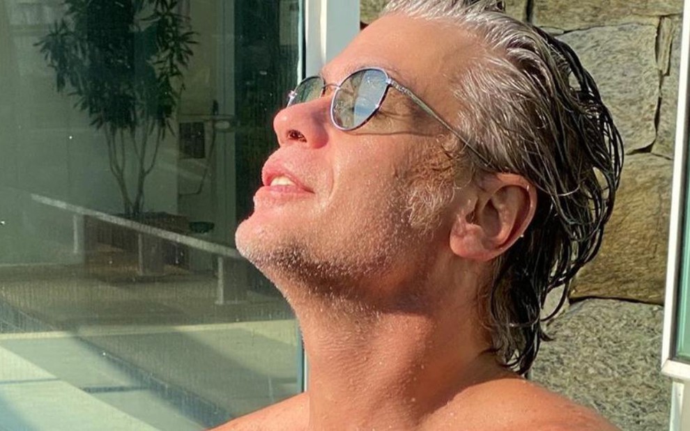 O ator Fabio Assunção com cabelos grisalhos, molhados, óculos de sol, tomando sol, em foto postada no Instagram