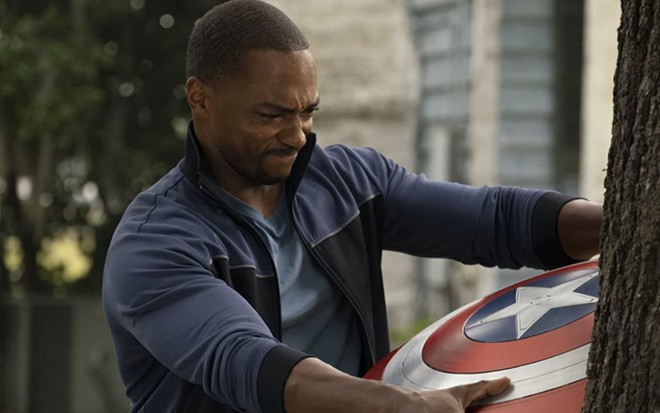 Anthony Mackie tenta retirar o escudo Capitão América de uma árvore em cena de Falcão e o Soldado Invernal