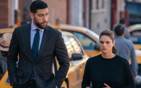 Com táxis amarelos ao fundo, os atores Zeeko Zaki e Missy Peregrym caminha por uma rua de Nova York na série FBI
