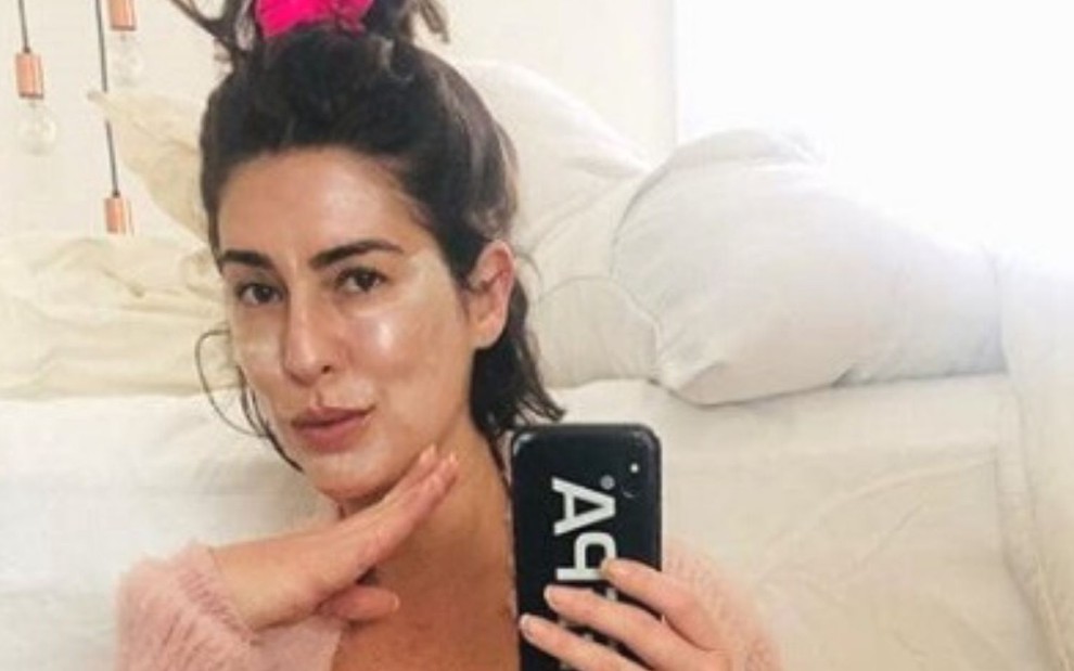 Com creme no rosto, Fernanda Paes Leme aponta celular para o espelho em foto no Instagram