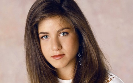 Com um cabelo alisado e escuro, Jennifer Aniston posa para foto que promoveu a comédia Ferris Bueller