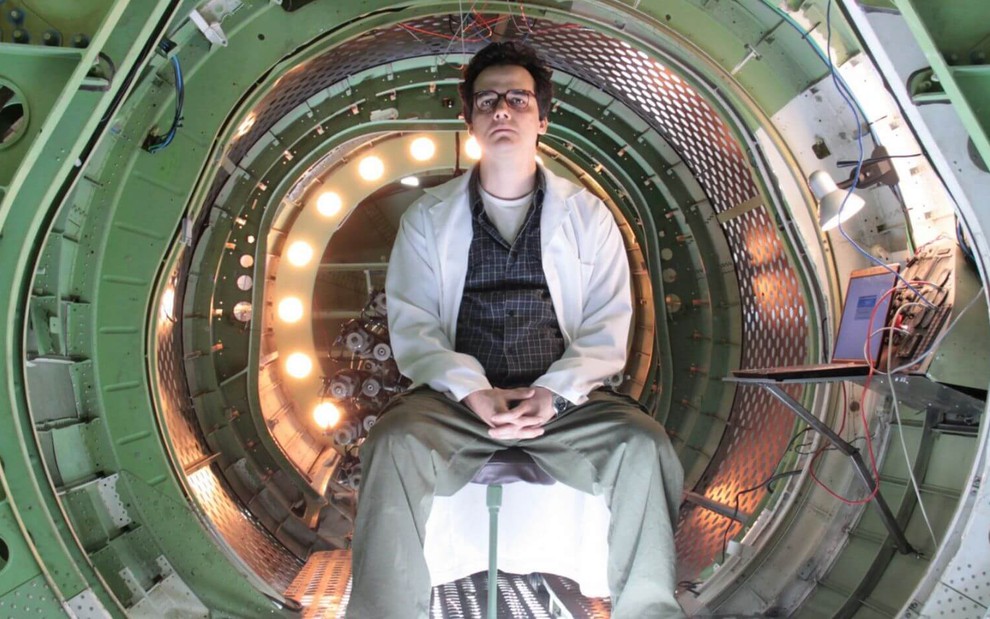 Wagner Moura interpretando um cientista dentro de uma máquina tempo no filme O Homem do Futuro