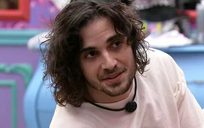 O cantor Fiuk na casa do BBB21 usando microfone em colar e camisa branca