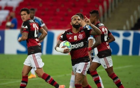 Com a bola na mão, Gabigol olha para cima e comemora gol do Flamengo; outros jogadores estão ao lado dele