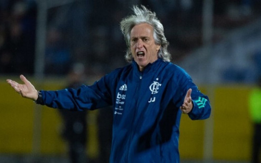 De braços abertos na beira do gramado, o técnico Jorge Jesus grita em jogo do Flamengo