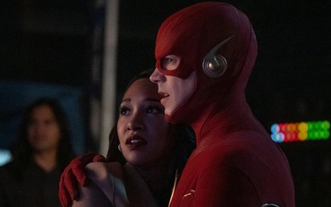 Assustada, a atriz Candice Patton abraça Grant Gustin, que veste o uniforme vermelho de Flash em cena da série homônima