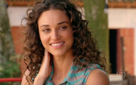 A atriz Débora Nascimento sorri em cena como Taís, sua personagem na novela Flor do Caribe, da Globo