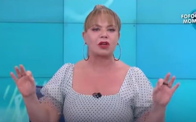 Flor Fernandez no Fofocalizando, com os braços abertos, de vestido de poá