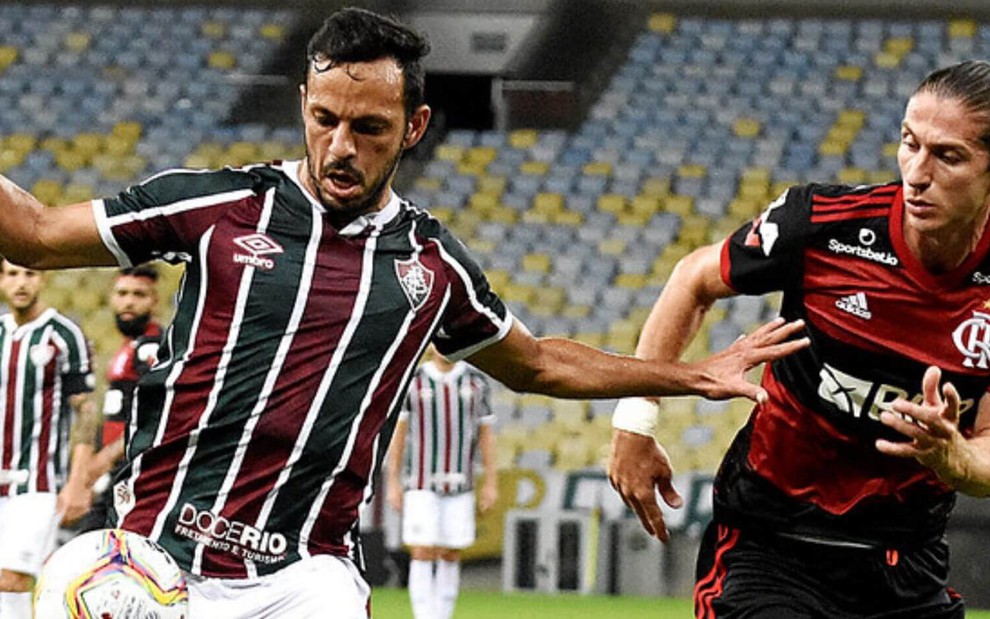 Nenê e Filipe Luís correm e disputam a bola em jogo entre Fluminense x Flamengo no Campeonato Carioca 2020