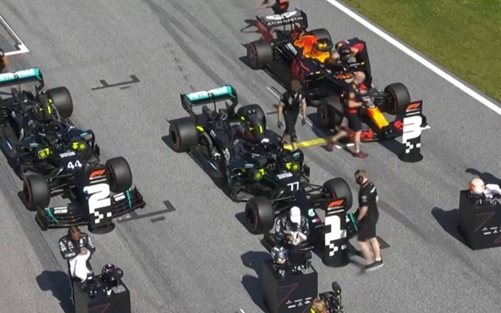 Três carros de Fórmula 1 sendo preparados para corrida em pista na Áustria
