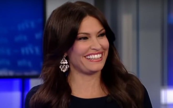 Sorridente, exibindo um brinco brilhante, Kimberly Guilfoyle aparece na na bancada do programa The Five, da Fox News