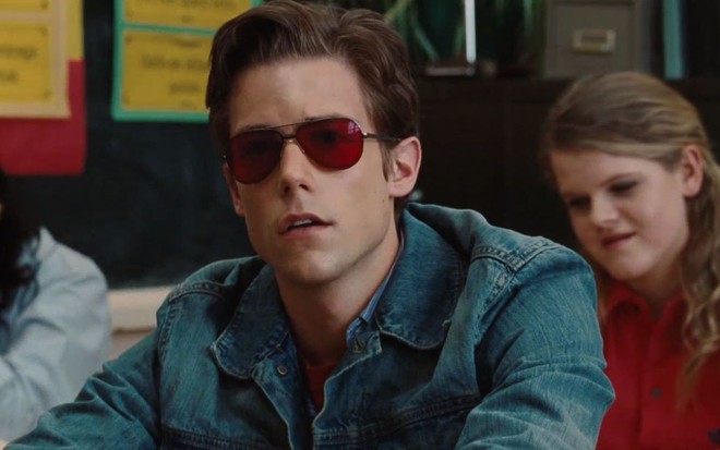 De jaqueta jeans e óculos vermelhos, Tim Pocock está caracterizado como o Ciclope de X-Men Origens: Wolverine (2009)