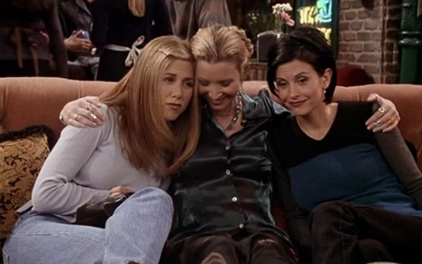 Jennifer Aniston, Lisa Kudrow e Courteney Cox se abraçam em cena da quarta temporada de Friends