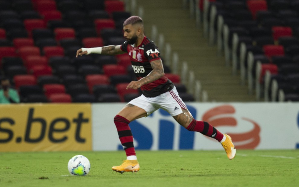 O jogador do Flamengo, Gabigol, em lance no campo vestido com o uniforme do time nas cores vermelho, preto e branco