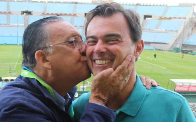 Galvão Bueno beija o rosto de Tino Marcos em um estádio de futebol