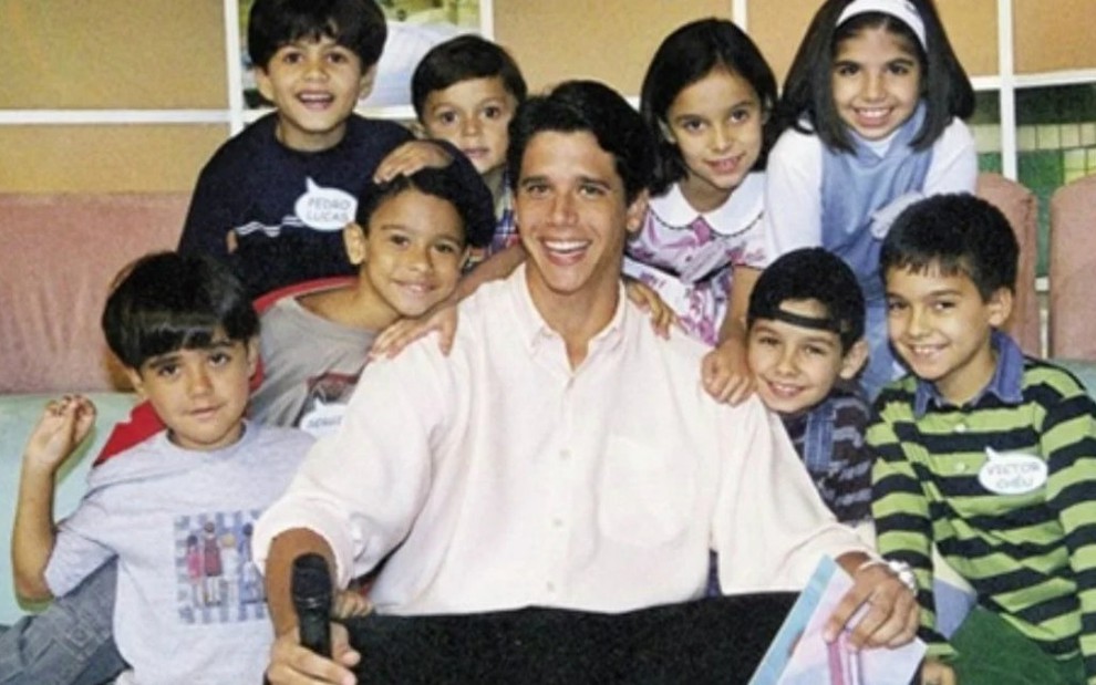 Márcio Garcia rodeado por algumas das crianças que fizeram parte do elenco do Gente Inocente, há 20 anos