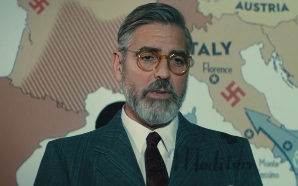 George Clooney usa óculos e terno em cena do filme Caçadores de Obras-Primas (2014)