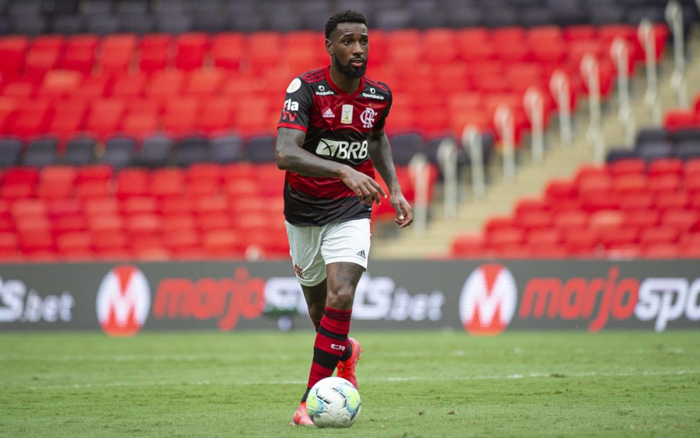 O jogador do Flamengo, Gerson, em lance no campo, vestido com o uniforme do time nas cores preto, vermelho e branco