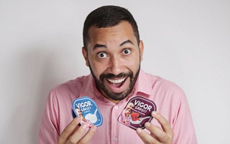 Gilberto Nogueira, ex-BBB, segura embalagens de iogurte com seu rosto e a inscrição da marca Vigor