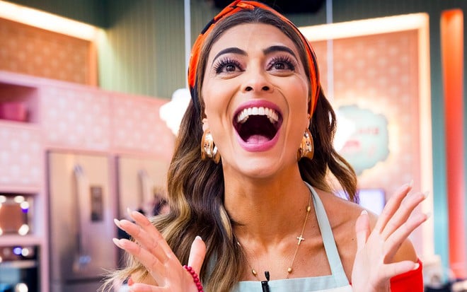 A atriz Juliana Paes, com um lenço na cabeça, boca aberta, e mãos espalmadas, em expressão de surpresa caracterizada como a Maria da Paz na cena em que a confeiteira vence o reality Best Cake em A Dona do Pedaço