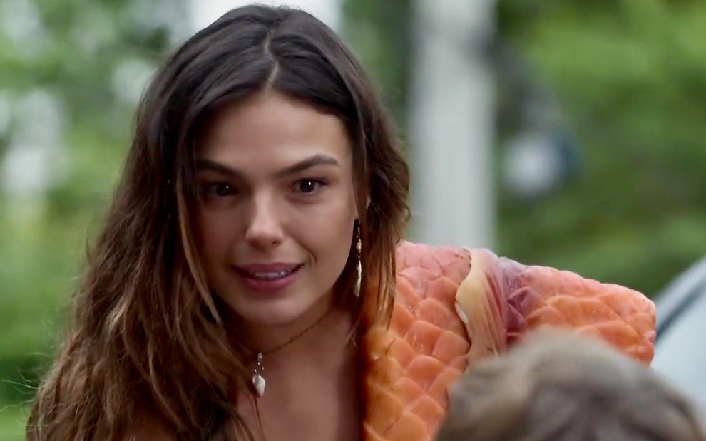 A atriz Isis Valverde grava cena com uma cauda de sereia pendurada no ombro na novela A Força do Querer
