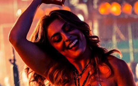 Juliana Paes sorri enquanto dança em cenário de baile durante gravação da novela A Força do Querer