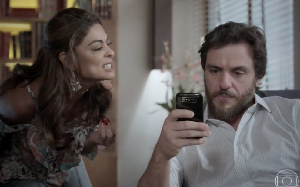 Juliana Paes e Rodrigo Lombardi em cena de A Força do Querer: atriz grita e olha com desprezo para o ator, já ele tem olhar tranquilo e encara o celular