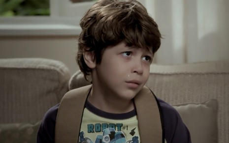 João Bravo em cena de A Força do Querer: triste, criança olha com cara de choro para alguém fora do quadro