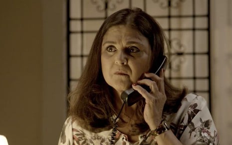 A atriz Elizângela fala ao telefone caracterizada como Aurora em cena de A Força do Querer