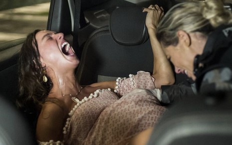 A atriz Isis Valverde grita de dor como a Ritinha enquanto Paolla Oliveira, a Jeiza, faz seu parto dentro de um carro em cena de A Força do Querer