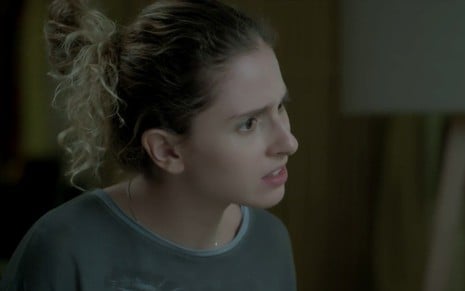 Carol Duarte caracterizada como Ivana em A Força do Querer: personagem está de cabelo preso e tem olhar pensativo