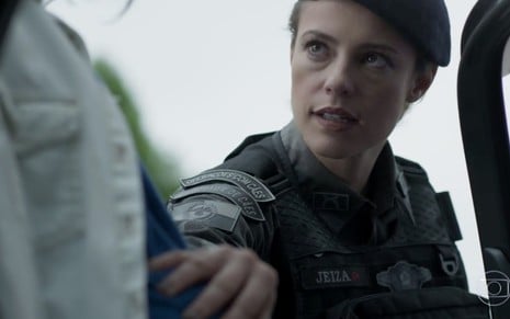 Paolla Oliveira caracterizada como Jeiza em A Força do Querer; com uniforme de policial, personagem tem olhar de seriedade para alguém fora do quadro