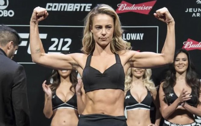 A atriz Paolla Oliveira mostra os bíceps enquanto sobe em uma balança durante um evento do UFC em cena de A Força do Querer