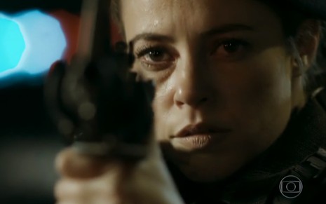 A atriz Paolla Oliveira com uma arma na mão, em cena como Jeiza em A Força do Querer