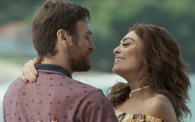 Emilio Dantas e Juliana Paes caracterizados em A Força do Querer: seus personagens estão abraçados e sorrindo