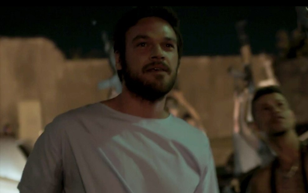 Emilio Dantas caracterizado como Rubinho em A Força do Querer: personagem está com roupa de hospital, e sorri para horizonte