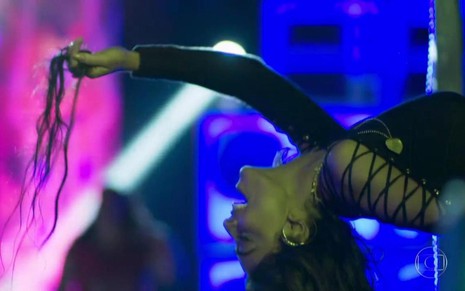 Juliana Paes na cena em que comemora vitória sobre rival na novela A Força do Querer; atriz dança em camarote e segura aplique de cabelo