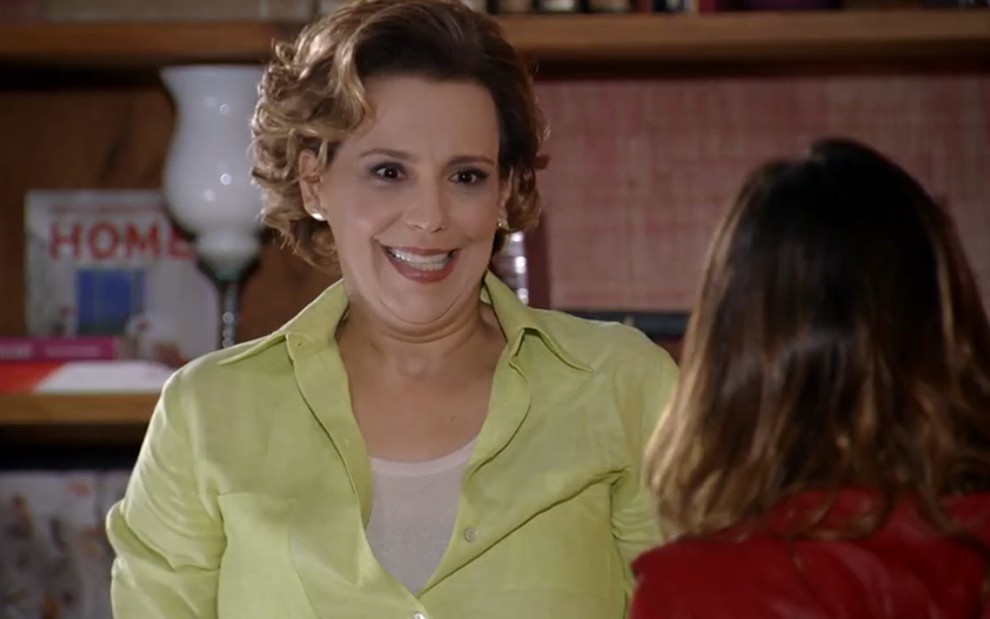 Ana Beatriz Nogueira grava de camisa amarela, cabelo curto e expressão feliz em conversa com Fernanda Vasconcellos