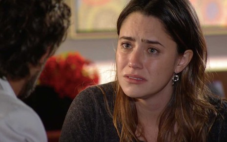 A atriz Fernanda Vasconcellos está com o rosto molhado por lágrimas e olhos vermelhos como a Ana em cena de A Vida da Gente