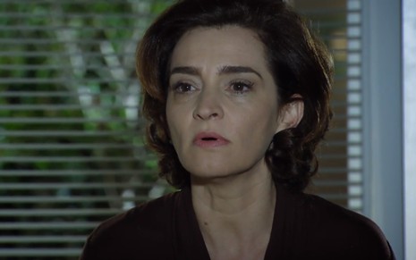 A atriz Gisele Fróes exibe expressão séria em cena como Vitória na novela A Vida da Gente, da TV Globo