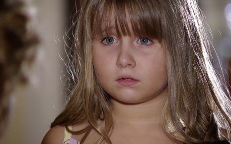 Um close-up do rosto da atriz Jesuela Moro, com cerca de seis anos de idade, como Júlia em cena de A Vida da Gente