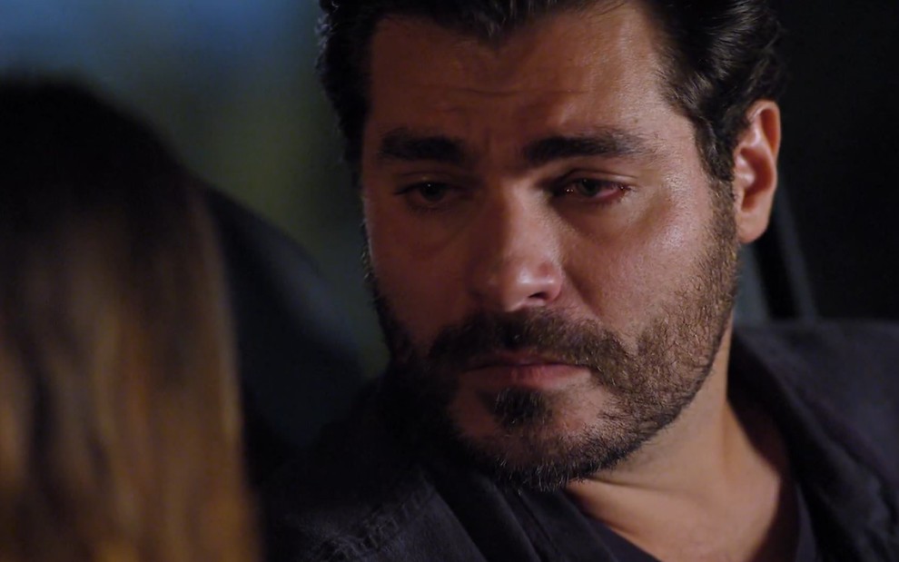 Thiago Lacerda grava com camisa preta, olhar triste e cara de choro como Lúcio de A Vida da Gente