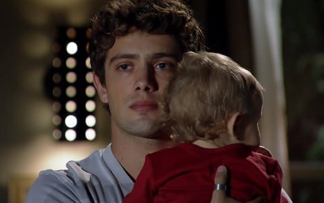 O ator Rafael Cardoso, com uma criança no colo, grava cena como Rodrigo em A Vida da Gente