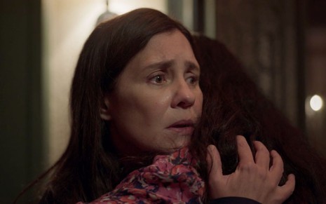 A atriz Adriana Esteves como a vilã Thelma abraça Lurdes (Regina Casé) em cena de Amor de Mãe