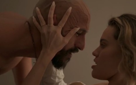 O ator Irandhir Santos com as mãos de Letícia Lima em sua cabeça em cena de Amor de Mãe em que eles simulam o início de uma transa